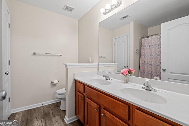 bathroom featuring vanity, wood-type flooring, and toilet