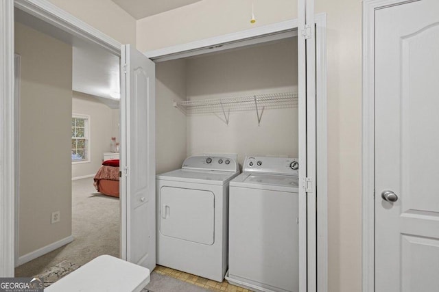 clothes washing area with washing machine and dryer and light carpet