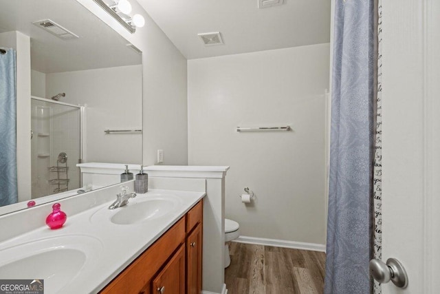 bathroom with hardwood / wood-style flooring, vanity, toilet, and curtained shower