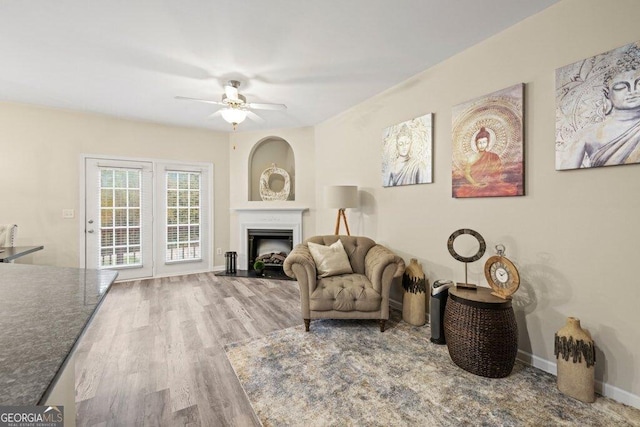 living area with wood-type flooring and ceiling fan