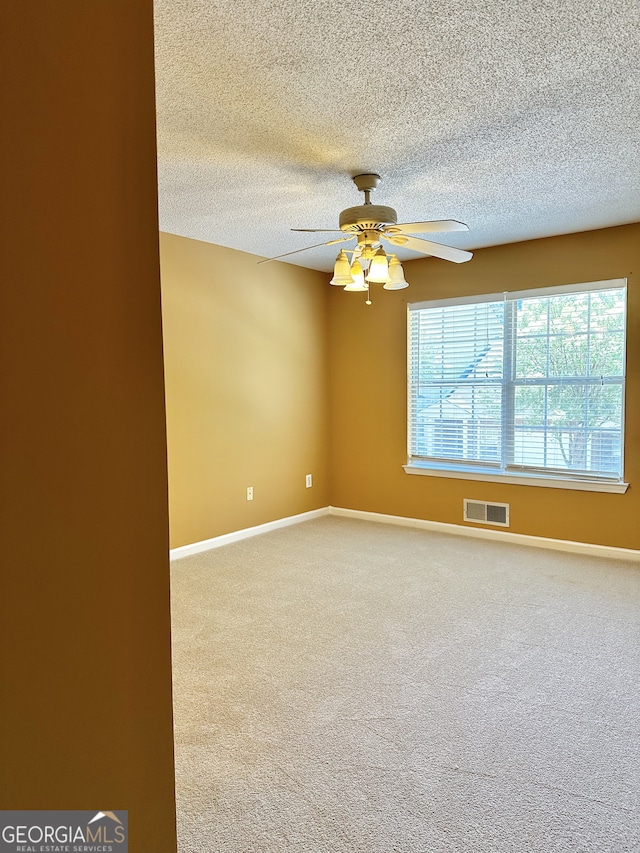 unfurnished room featuring carpet flooring, a textured ceiling, and ceiling fan