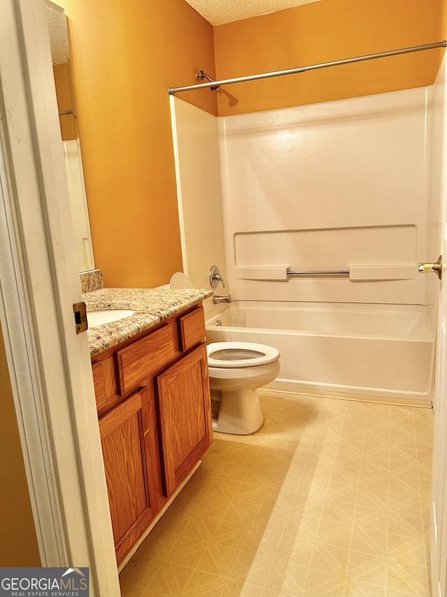 full bathroom featuring vanity, toilet,  shower combination, and a textured ceiling