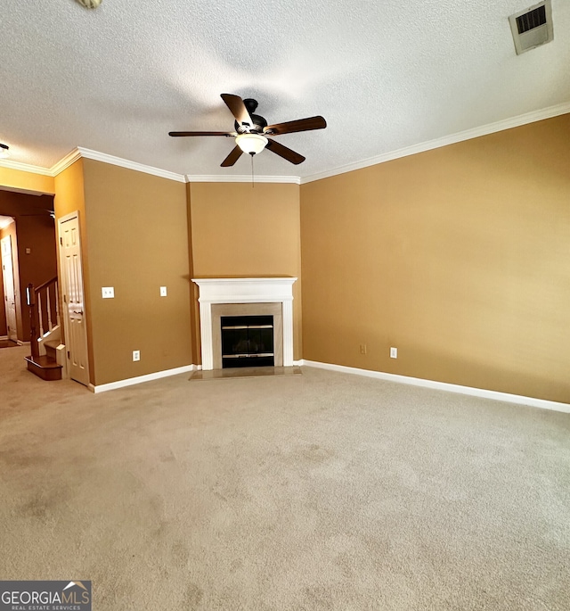 unfurnished living room featuring a textured ceiling, ornamental molding, ceiling fan, and carpet