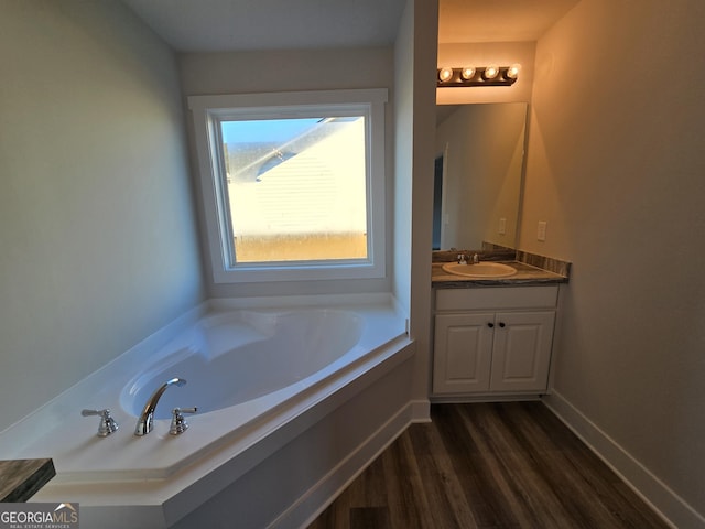 bathroom featuring hardwood / wood-style flooring, vanity, and a tub