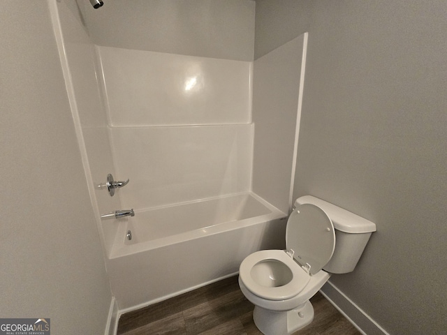 bathroom with toilet, tub / shower combination, and hardwood / wood-style floors