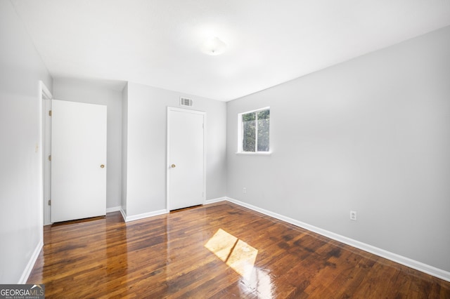 unfurnished bedroom with dark wood-type flooring