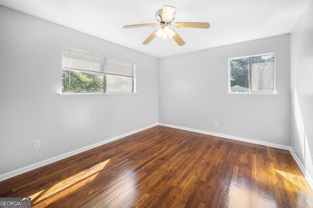 spare room with dark hardwood / wood-style floors and ceiling fan