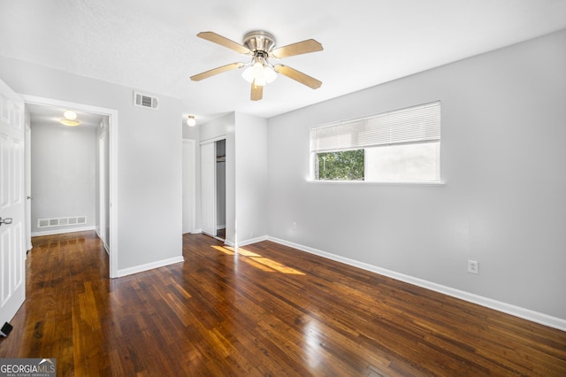 empty room featuring ceiling fan and dark hardwood / wood-style flooring