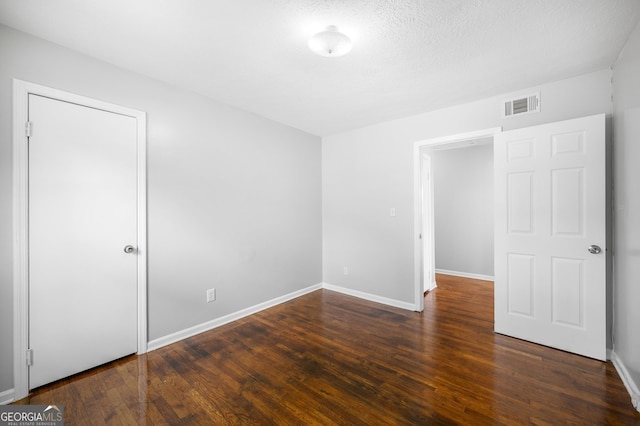 unfurnished bedroom featuring dark wood-type flooring