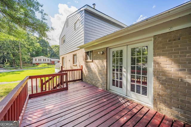 deck with french doors and a lawn