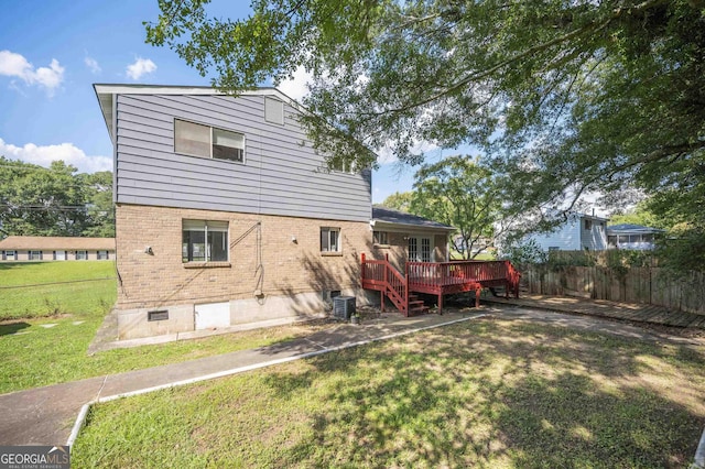 back of property featuring a wooden deck, central AC, and a lawn