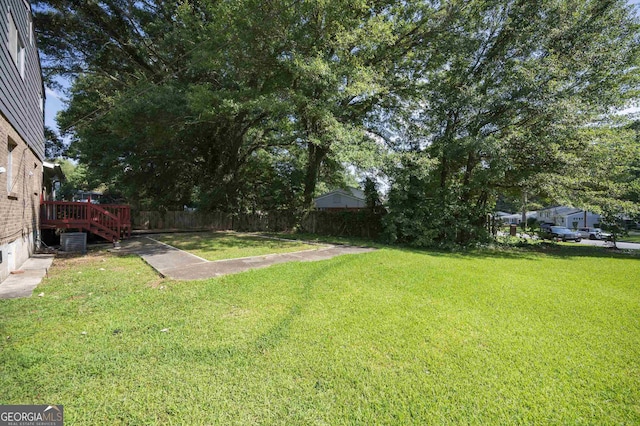 view of yard featuring central AC and a deck