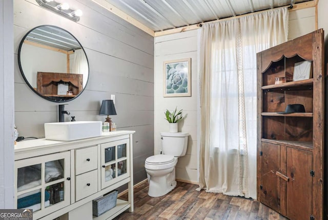 bathroom with hardwood / wood-style flooring, vanity, and toilet