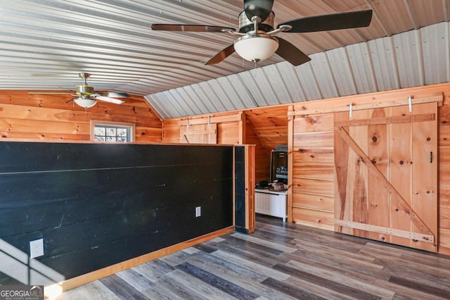 interior space featuring hardwood / wood-style floors, wood walls, lofted ceiling, ceiling fan, and wooden ceiling