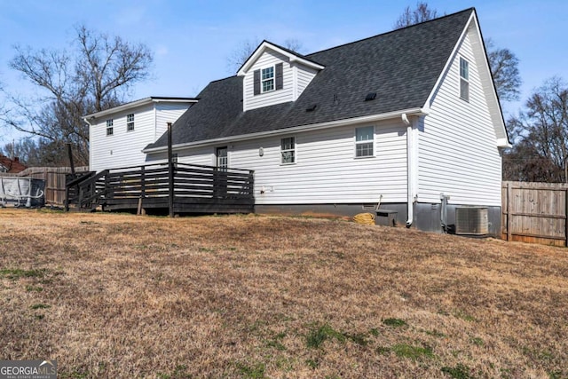 rear view of property featuring a yard, central air condition unit, and a deck