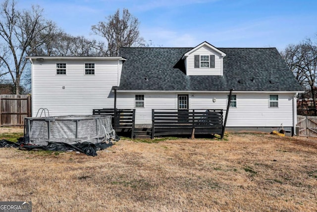 rear view of house with a pool side deck and a lawn