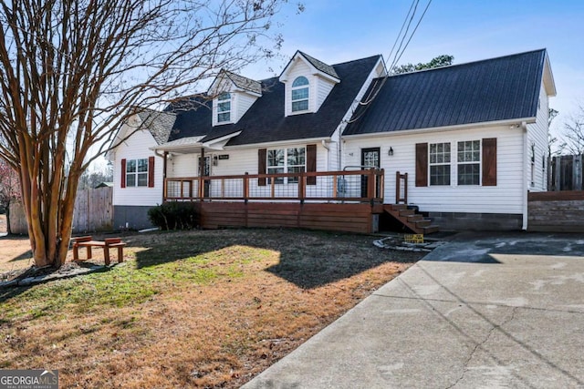 new england style home featuring a front lawn and a deck