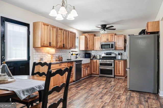 kitchen with tasteful backsplash, stainless steel appliances, dark hardwood / wood-style flooring, and hanging light fixtures