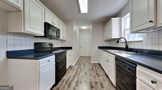 kitchen featuring white cabinetry, sink, black appliances, and light wood-type flooring