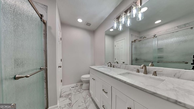 bathroom featuring a shower with door, vanity, and toilet