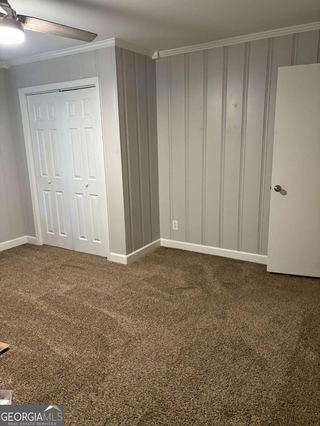 unfurnished bedroom featuring baseboards, a closet, carpet flooring, and crown molding