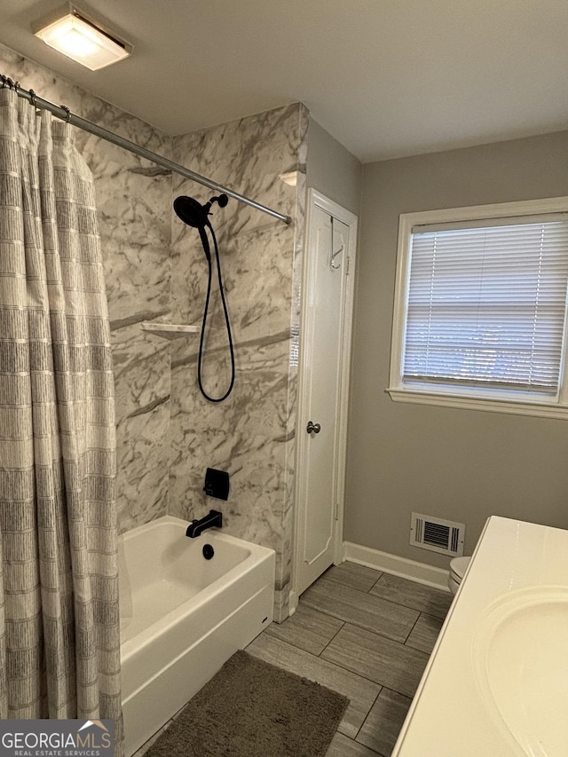 full bath with shower / bath combination with curtain, visible vents, a sink, and baseboards