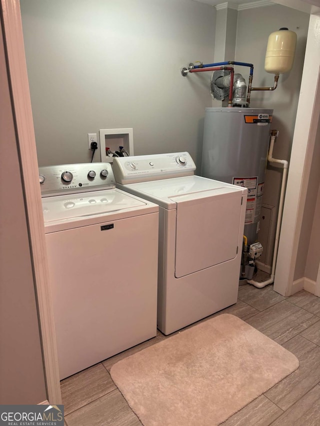 laundry room featuring water heater, laundry area, washer and clothes dryer, and light wood-type flooring