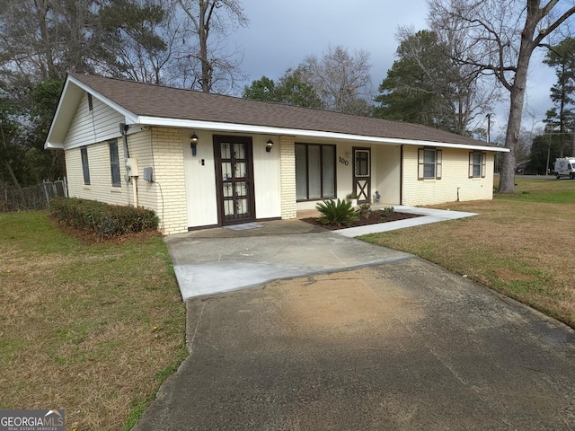 ranch-style home featuring covered porch and a front yard