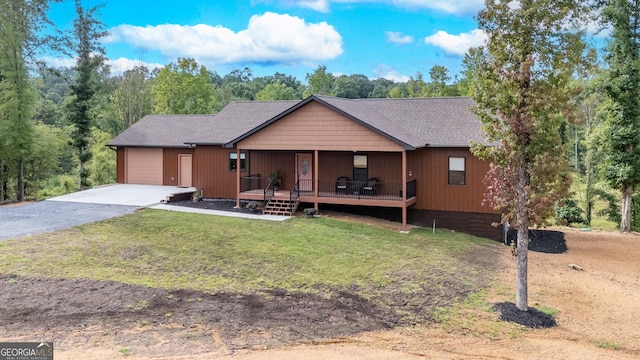 single story home with a garage, a front lawn, and covered porch