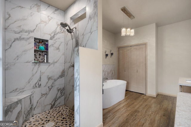 bathroom featuring hardwood / wood-style flooring, vanity, plus walk in shower, and a chandelier