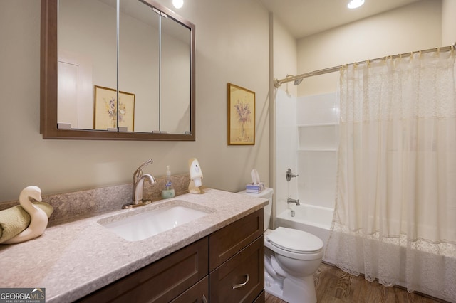 full bathroom featuring hardwood / wood-style flooring, vanity, shower / bath combination with curtain, and toilet