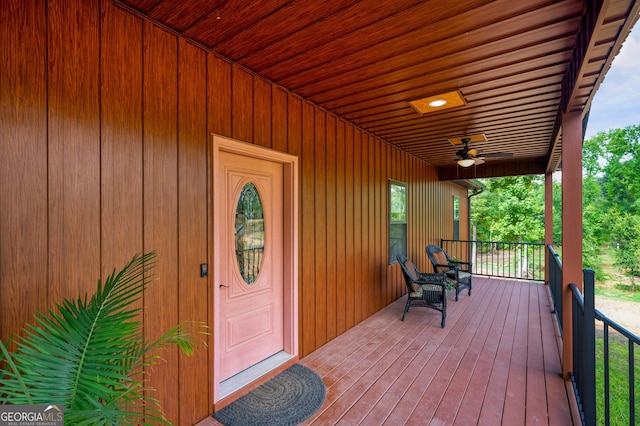 view of exterior entry with ceiling fan and covered porch