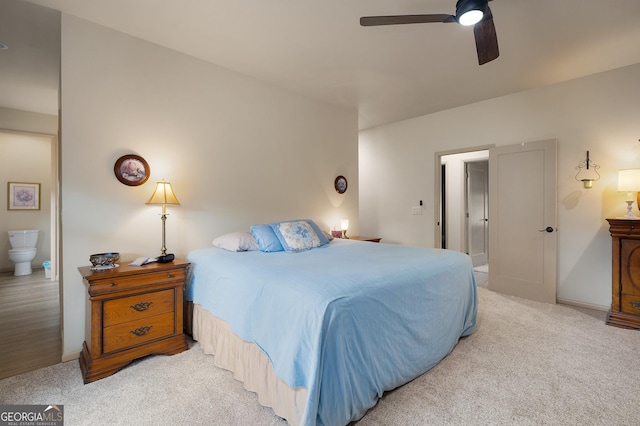 bedroom featuring light carpet, connected bathroom, and ceiling fan