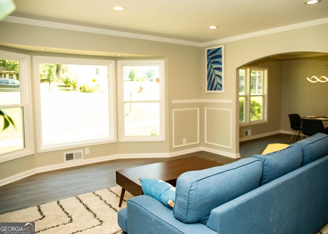 living room featuring crown molding, wood finished floors, arched walkways, and visible vents