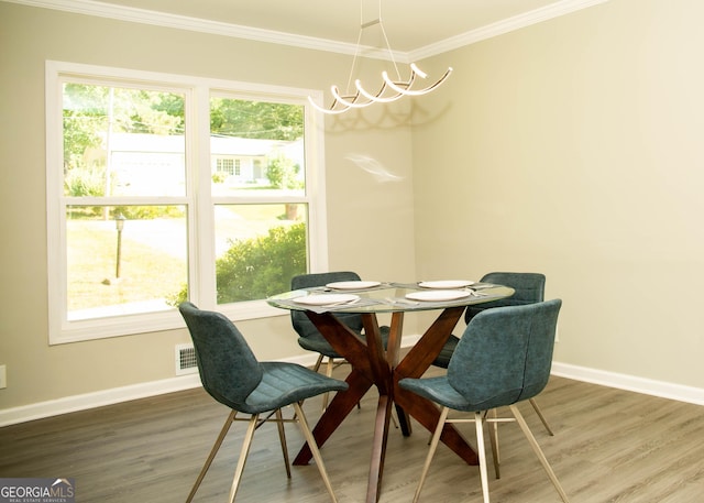 dining area featuring a chandelier, crown molding, baseboards, and wood finished floors