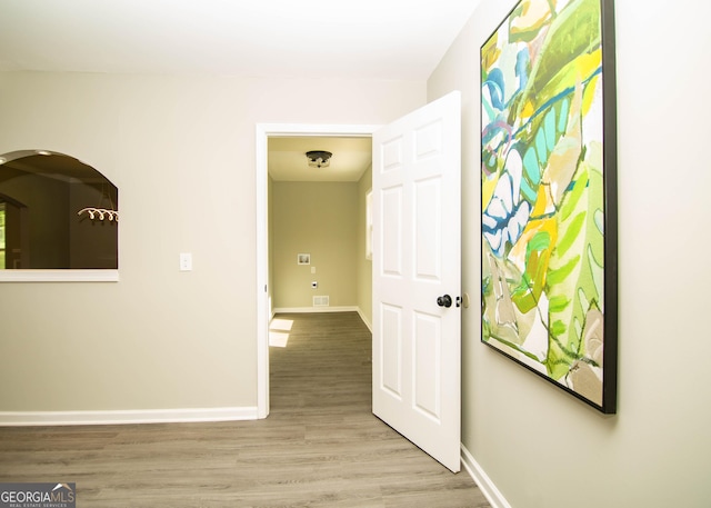 hall with wood finished floors and baseboards