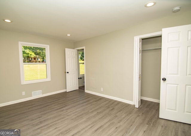 unfurnished bedroom featuring visible vents, recessed lighting, baseboards, and wood finished floors