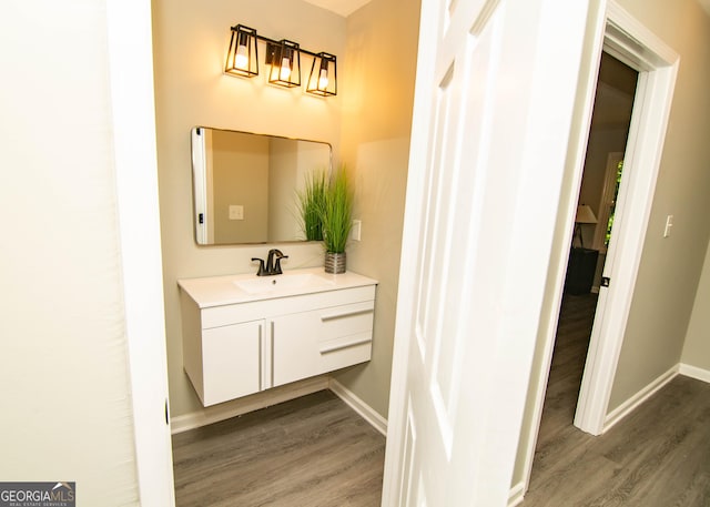 bathroom with vanity, baseboards, and wood finished floors