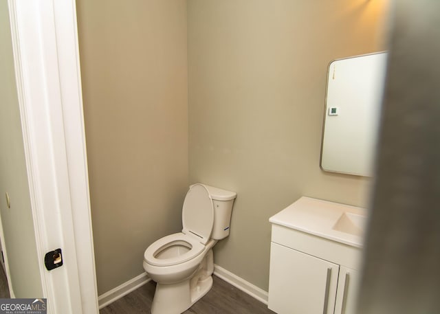 bathroom featuring vanity, toilet, wood finished floors, and baseboards