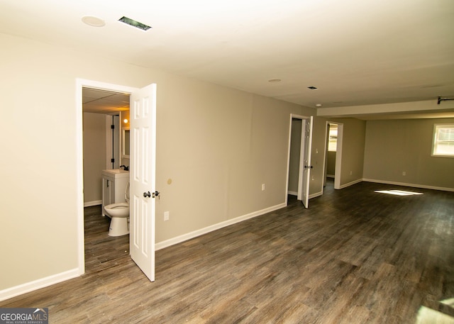 unfurnished living room featuring dark wood-style floors, visible vents, and baseboards