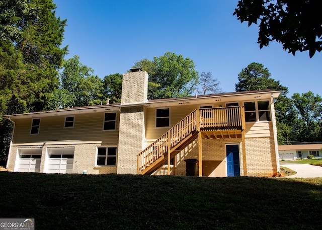 rear view of house with stairway, a lawn, brick siding, and a chimney