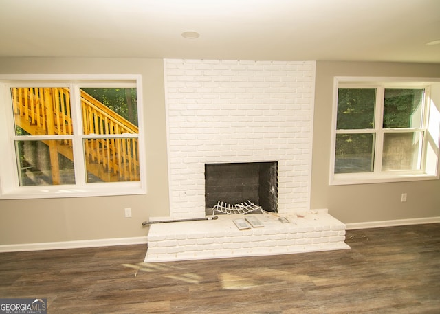 unfurnished living room featuring wood finished floors, a fireplace, and baseboards