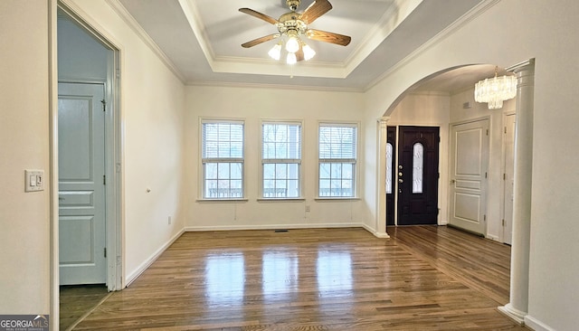 entrance foyer with ceiling fan, ornamental molding, wood-type flooring, and a tray ceiling