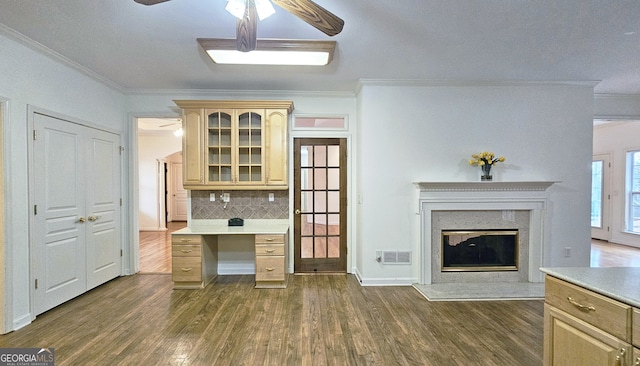 interior space with light brown cabinetry, a high end fireplace, dark hardwood / wood-style floors, and ceiling fan