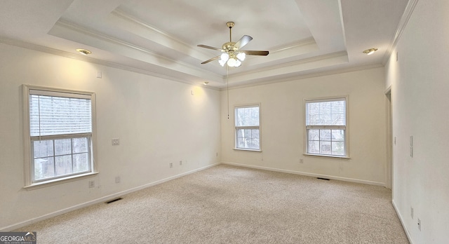 unfurnished room featuring light carpet, a tray ceiling, and crown molding