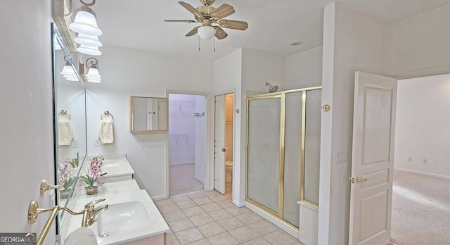 bathroom with ceiling fan, vanity, a shower with door, and tile patterned floors