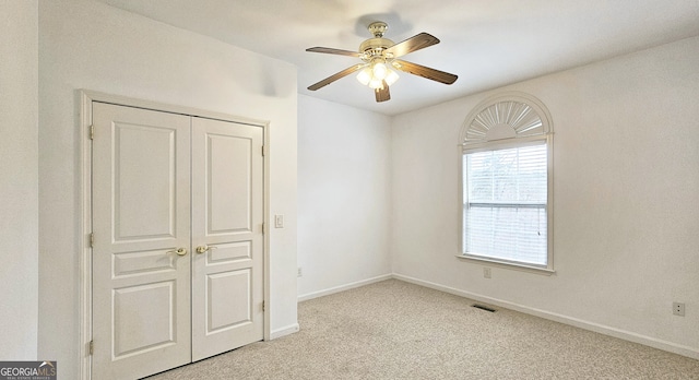 unfurnished bedroom with light carpet, ceiling fan, and a closet