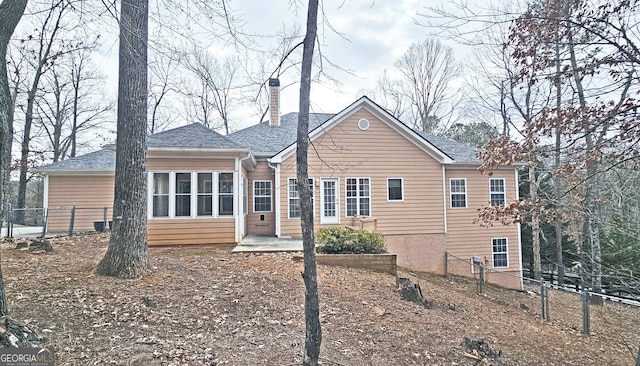 rear view of house featuring a patio and a sunroom