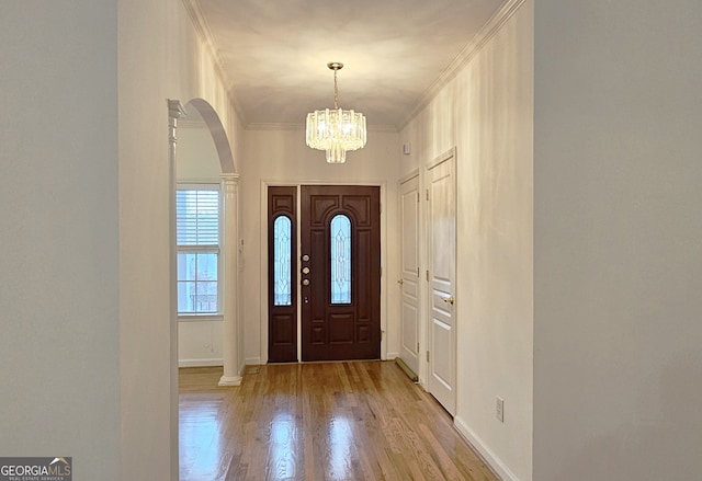 foyer featuring ornamental molding, a chandelier, and light wood-type flooring