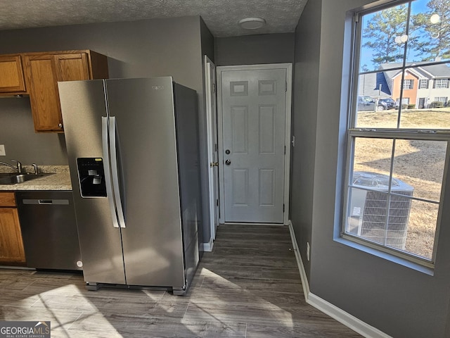 kitchen featuring stainless steel appliances, sink, a textured ceiling, and dark hardwood / wood-style floors